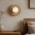 Tama wall light, a natural travertine ring holding a frosted glass globe