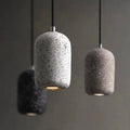 Hoshi pendant lights, small speckled terrazzo shades glowing in a row