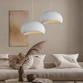 Kumo pendant lights, soft stone-textured domes glowing over a coastal living room