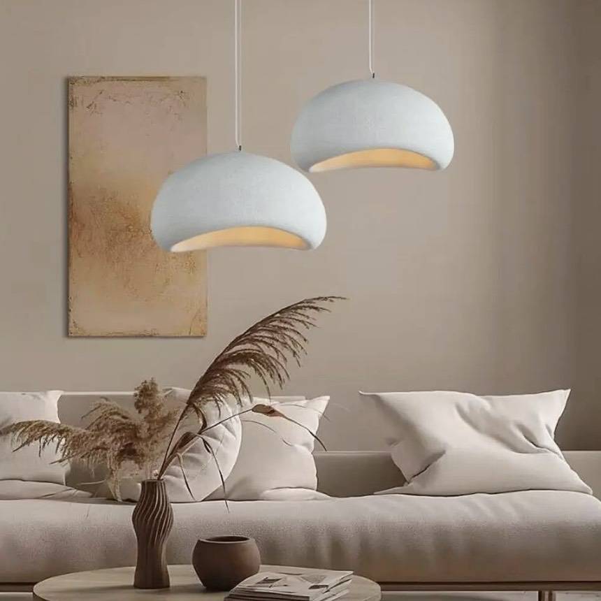 Kumo pendant lights, soft stone-textured domes glowing over a coastal living room