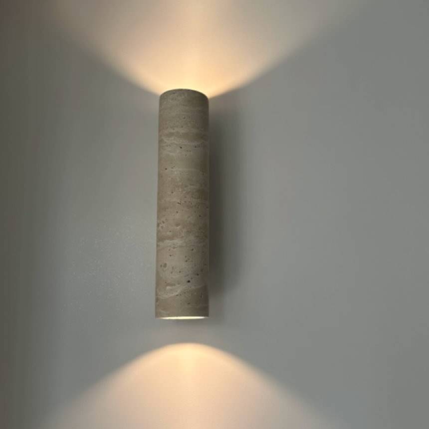 Take wall light, a tall natural travertine cylinder glowing up and down the wall