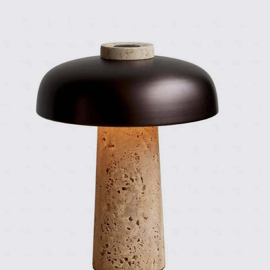 Yoru cordless lamp, a natural travertine base beneath a dark metal dome